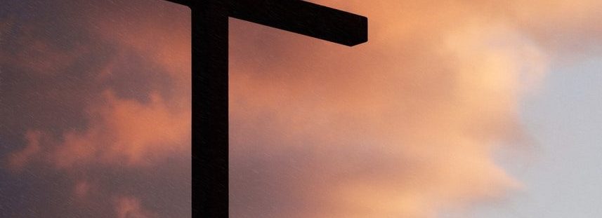 silhouette of large cross under orange sky